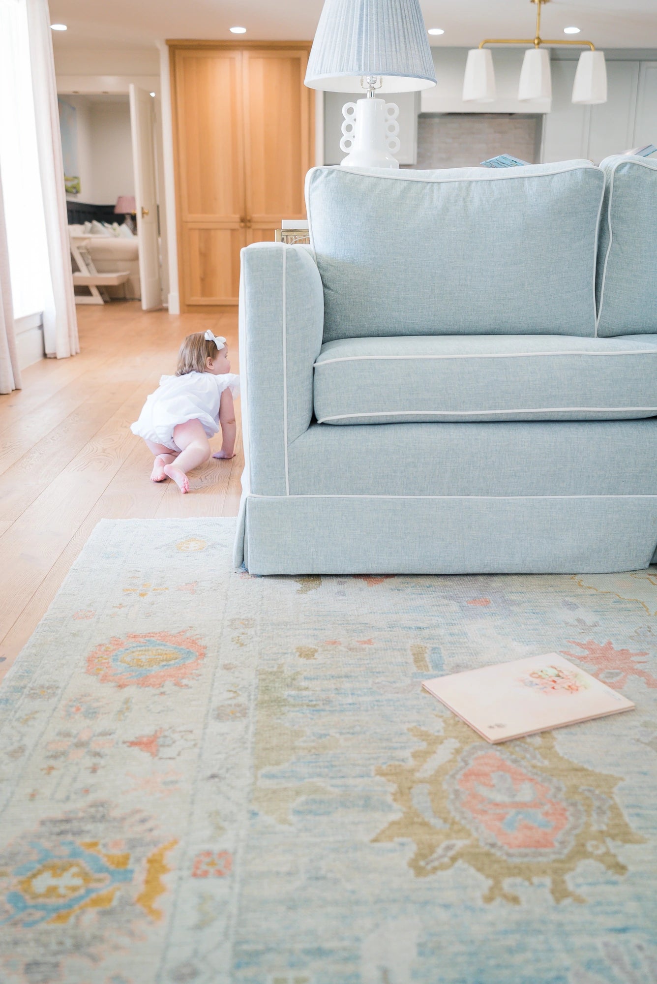 Light blue sofa in a living room with a child playing on the floor.